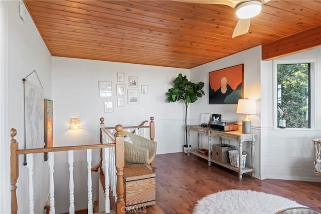 living area with wood ceiling, wood finished floors, and an upstairs landing