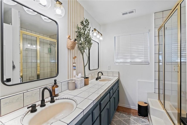 full bathroom featuring visible vents, a sink, and a tile shower