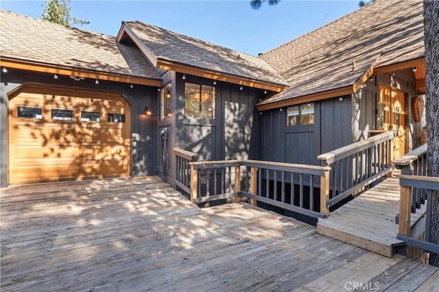 deck with a garage and driveway