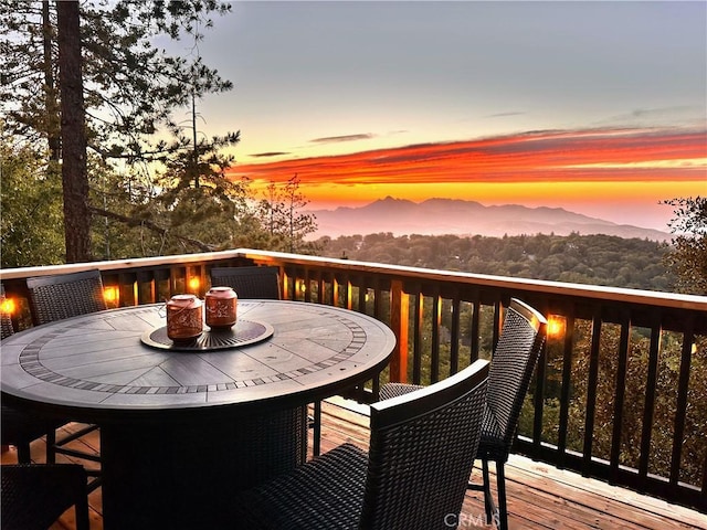 wooden deck featuring outdoor dining area and a mountain view