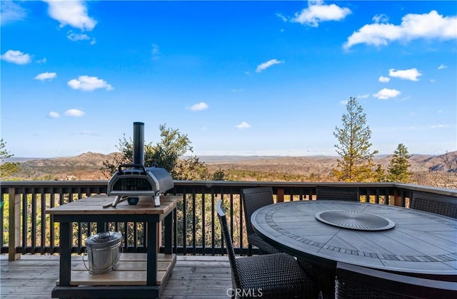 deck featuring outdoor dining area and a mountain view