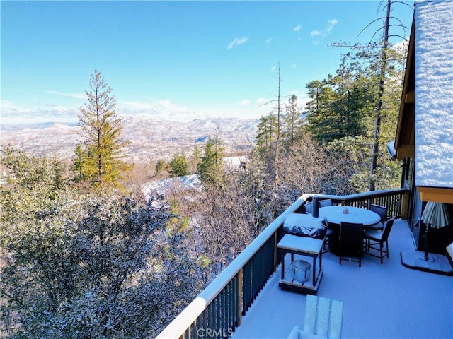 balcony with a mountain view and outdoor dining space