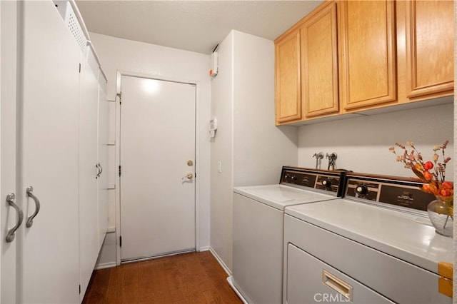 washroom featuring cabinets, dark hardwood / wood-style flooring, and washer and clothes dryer