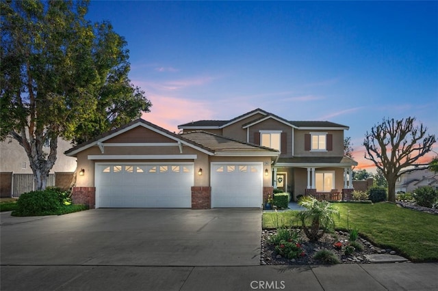 view of front of house with a garage and a yard