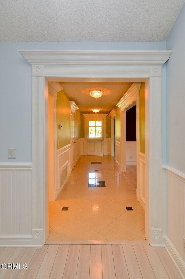 hallway with light tile patterned floors and a textured ceiling