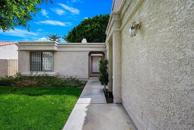 doorway to property with a lawn