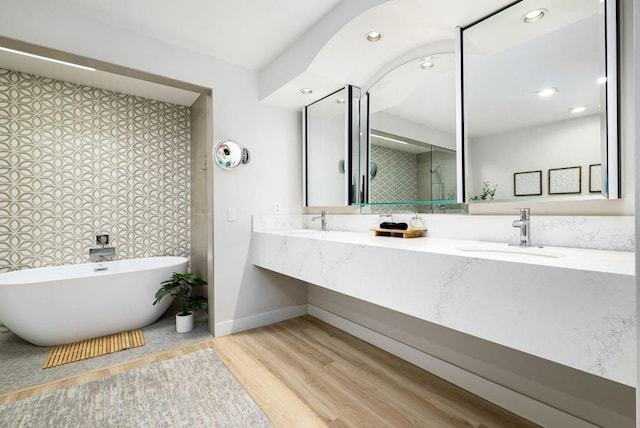 bathroom featuring wood-type flooring, vanity, and a bathtub