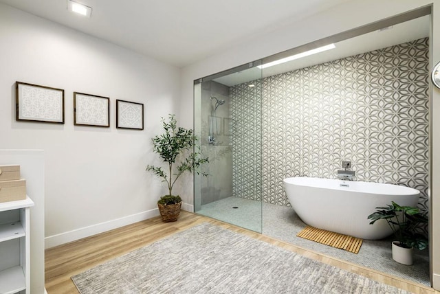 bathroom with shower with separate bathtub and wood-type flooring