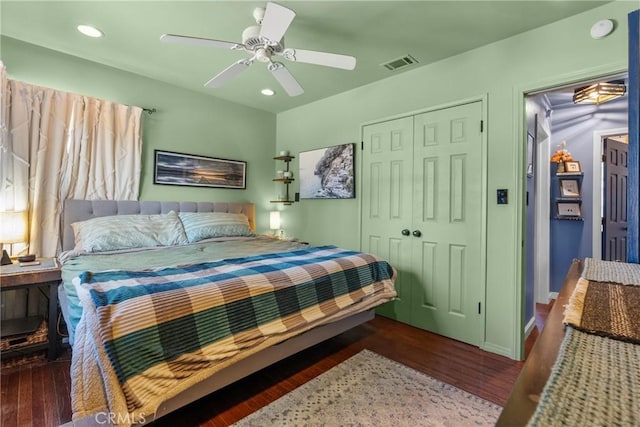 bedroom with a closet, dark hardwood / wood-style floors, and ceiling fan