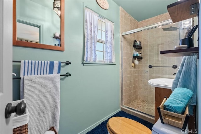 bathroom with vanity, a shower with shower door, and toilet