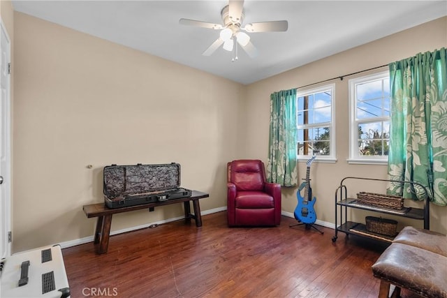 living area featuring ceiling fan and dark hardwood / wood-style flooring