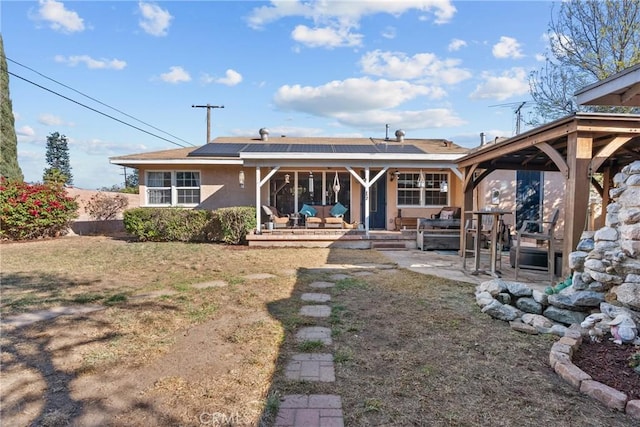 rear view of property with a patio area, solar panels, and a lawn