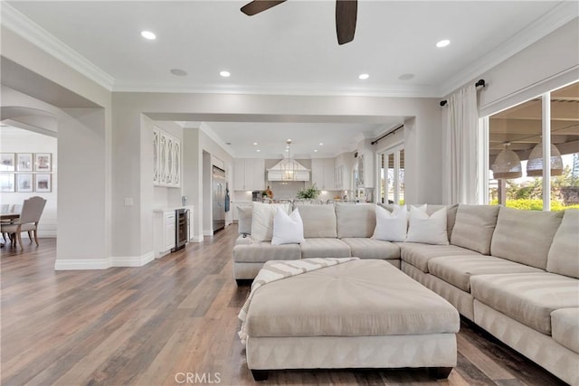 living room featuring hardwood / wood-style flooring, ornamental molding, wine cooler, and ceiling fan