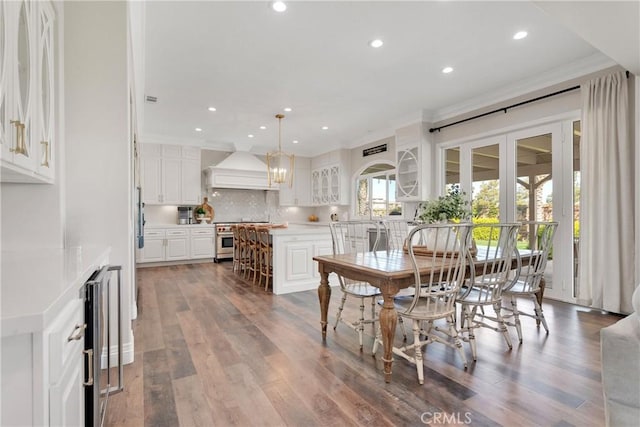 dining space featuring crown molding, hardwood / wood-style floors, and wine cooler