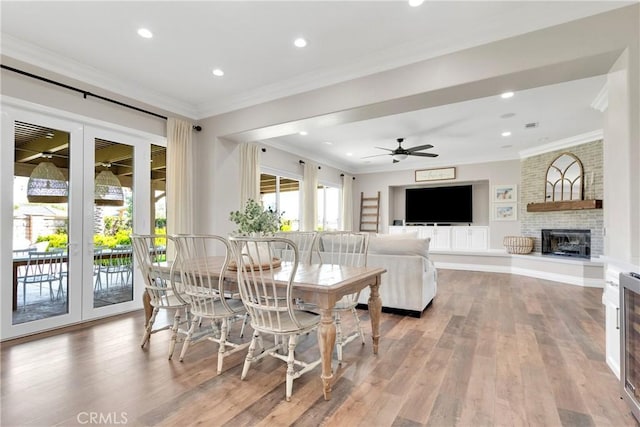 dining area with french doors, crown molding, and light hardwood / wood-style flooring