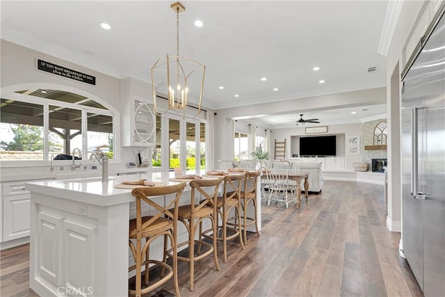 kitchen with white cabinetry, a breakfast bar area, a healthy amount of sunlight, and built in refrigerator