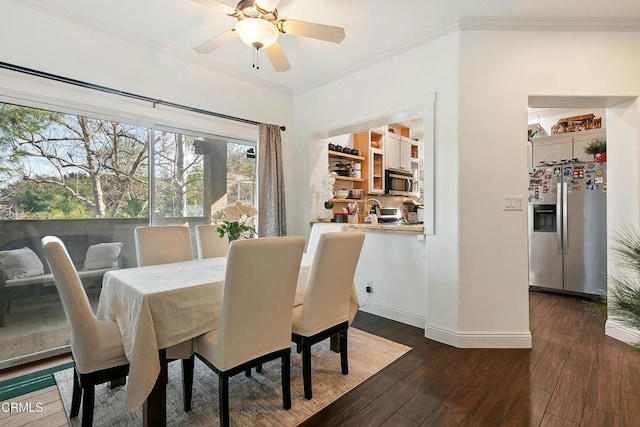 dining area featuring dark wood-style floors, ornamental molding, a ceiling fan, and baseboards