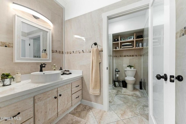bathroom with toilet, tile walls, and vanity