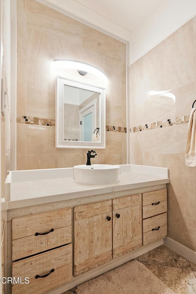 bathroom featuring vanity and tile walls