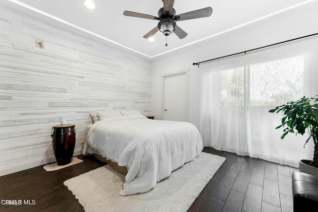 bedroom featuring dark wood-type flooring, a ceiling fan, and baseboards