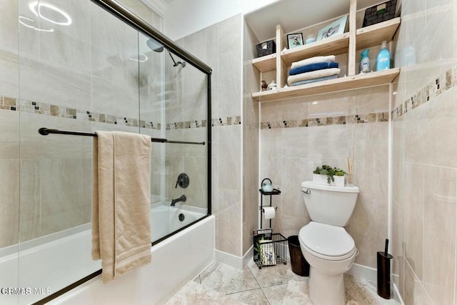 bathroom with combined bath / shower with glass door, tile walls, and toilet