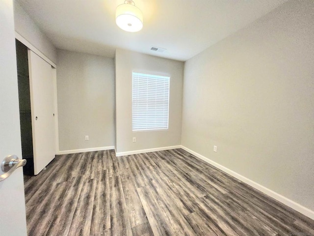 unfurnished bedroom featuring dark wood-type flooring and a closet