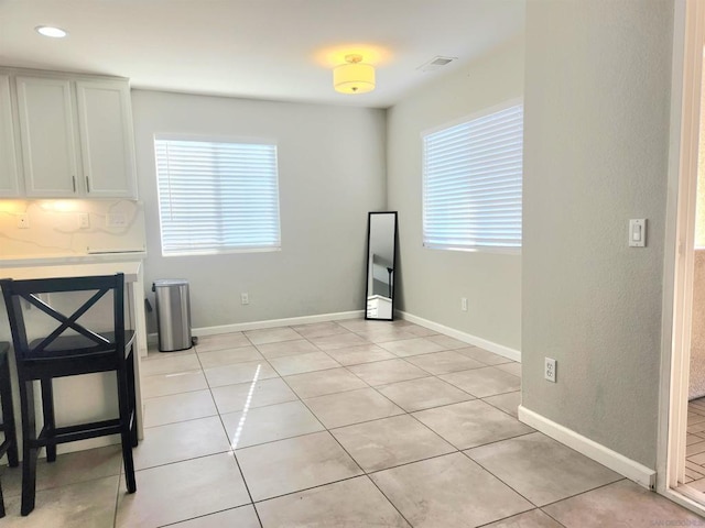 unfurnished dining area featuring light tile patterned floors