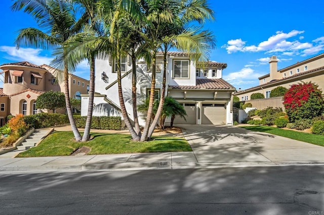 mediterranean / spanish home with a garage, driveway, a tile roof, and stucco siding