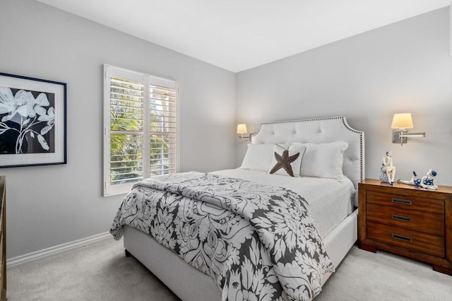 bedroom featuring baseboards and light colored carpet