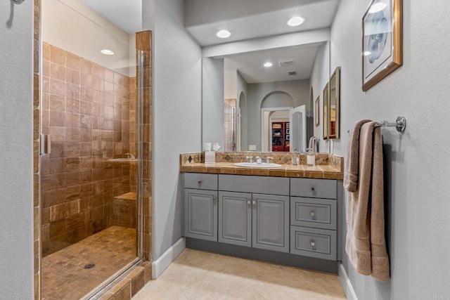 bathroom with a shower stall, baseboards, tile patterned flooring, and vanity