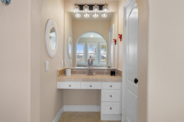 bathroom with vanity, baseboards, and tile patterned floors