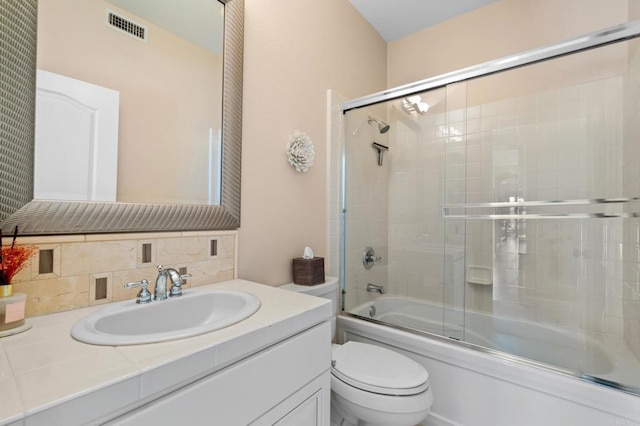 full bath featuring shower / bath combination with glass door, visible vents, decorative backsplash, toilet, and vanity