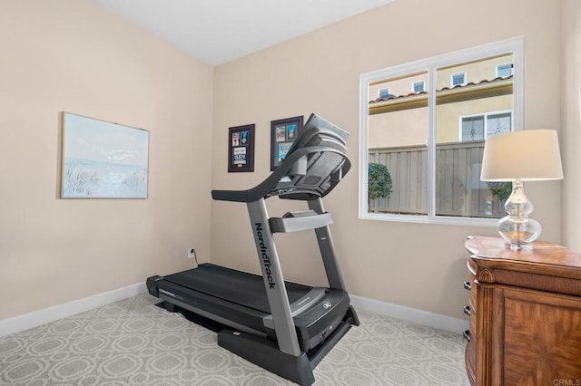 workout room featuring baseboards and carpet floors