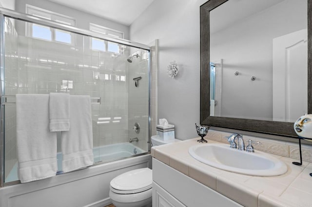 full bath with toilet, shower / bath combination with glass door, and vanity