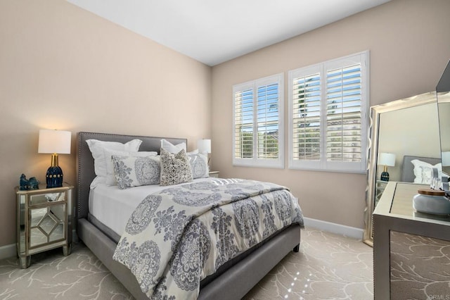 bedroom with baseboards and light colored carpet