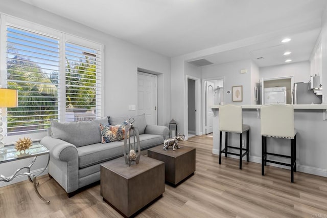 living room with light wood-type flooring, recessed lighting, baseboards, and visible vents