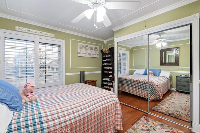 bedroom with hardwood / wood-style flooring, ornamental molding, a closet, and ceiling fan