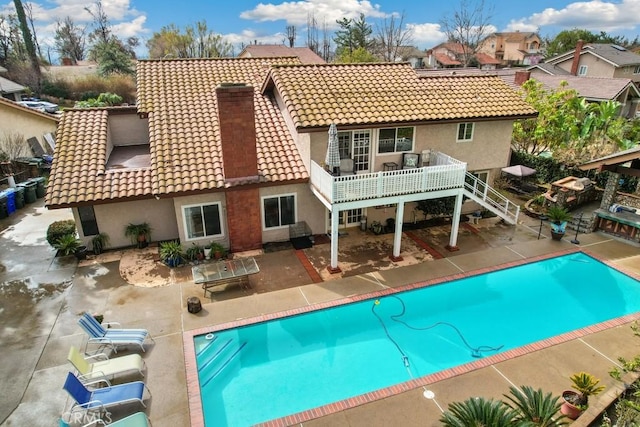 back of property featuring a pool side deck and a patio area