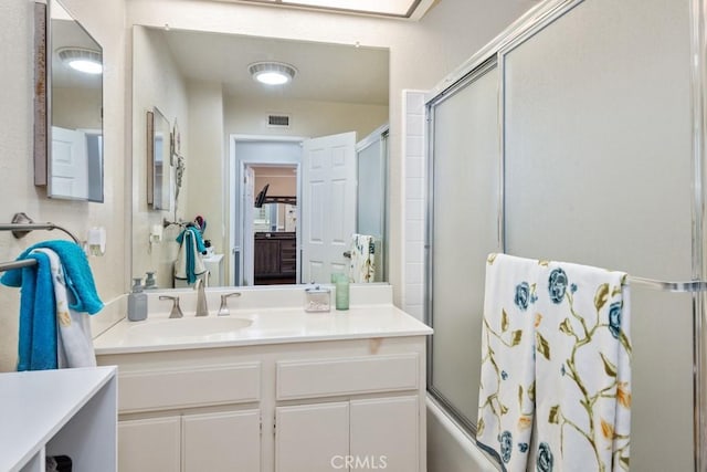 bathroom with vanity and shower / bath combination with glass door