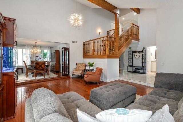 living room featuring wood-type flooring, high vaulted ceiling, beamed ceiling, and a chandelier