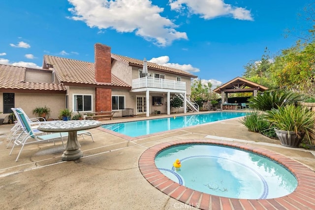 view of swimming pool with an in ground hot tub, a patio area, and a gazebo