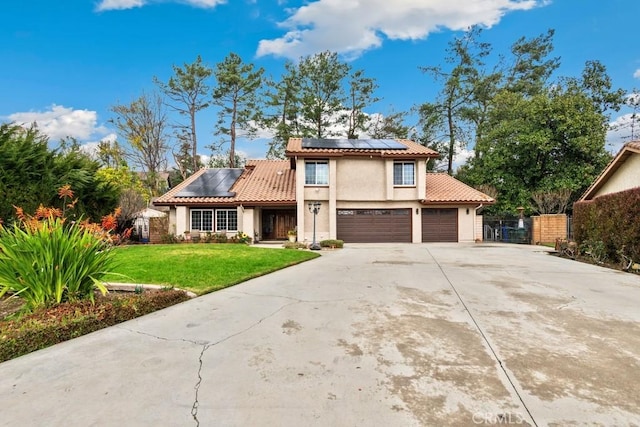 mediterranean / spanish-style house with a garage, a front yard, and solar panels