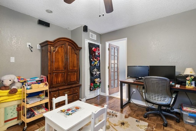 office space featuring ceiling fan, dark parquet flooring, and a textured ceiling