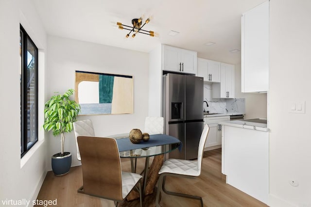 dining space with sink and light wood-type flooring