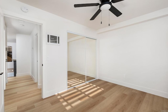 unfurnished bedroom with ceiling fan, a closet, and light hardwood / wood-style flooring