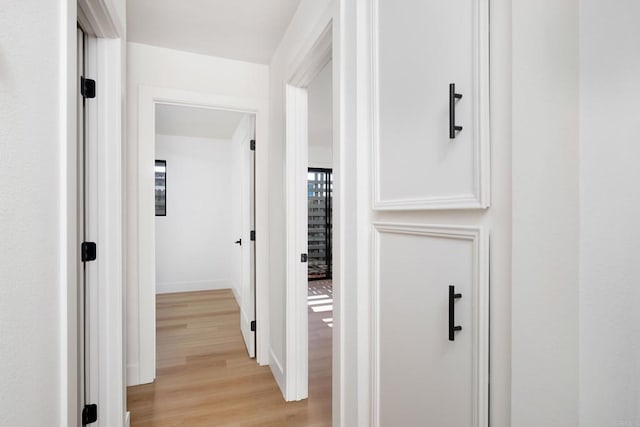 hallway with light hardwood / wood-style floors