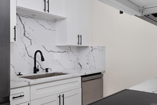 kitchen with white cabinetry, sink, light stone counters, and white dishwasher