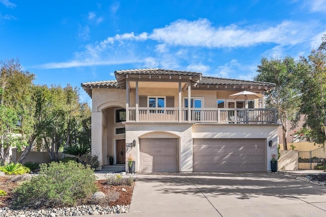 mediterranean / spanish-style home featuring a garage and a balcony