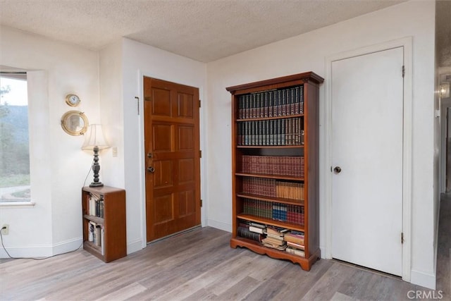 foyer with light hardwood / wood-style flooring and a textured ceiling