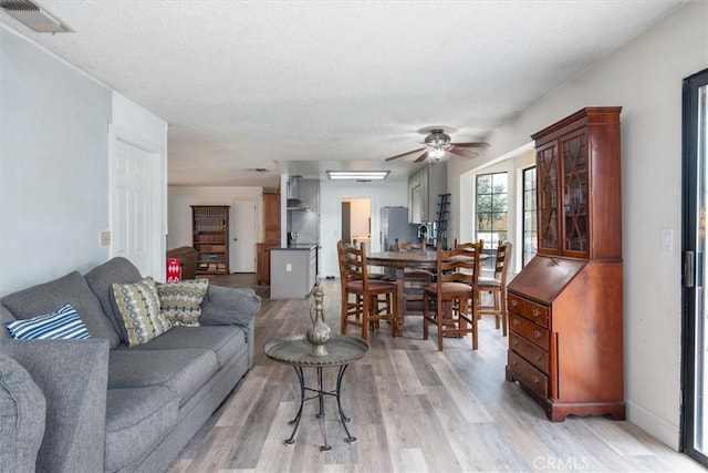 living room featuring ceiling fan and light wood-type flooring